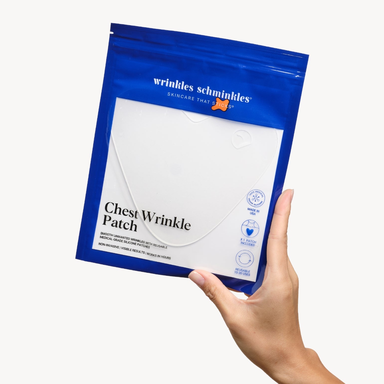 Main tenant un sachet du Patch Anti-Rides Décolleté de Wrinkles Schminkles. Silicone haute qualité.