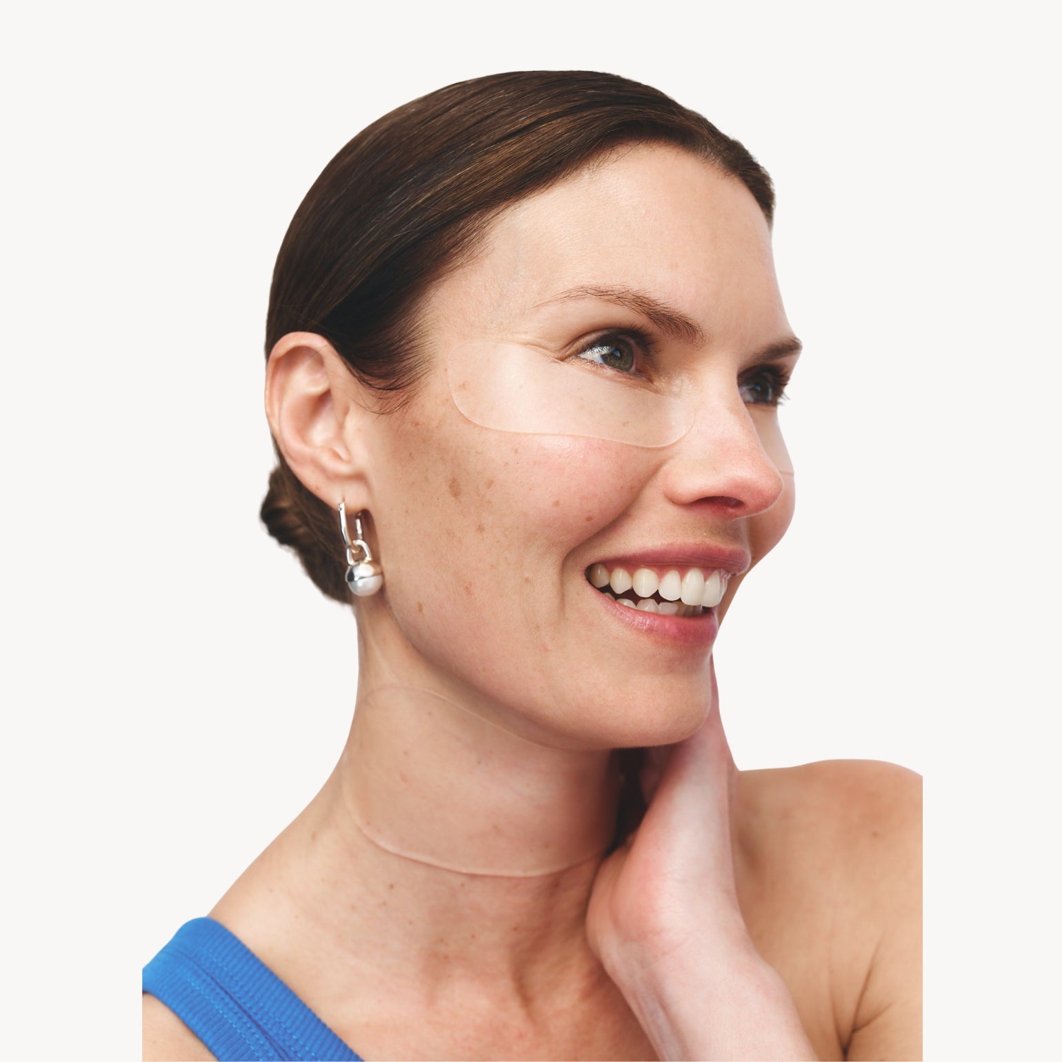 Modèle portant un Patch Anti-Rides Des Yeux de Wrinkles Schminkles. Traite les rides de la patte d'oie efficacement.