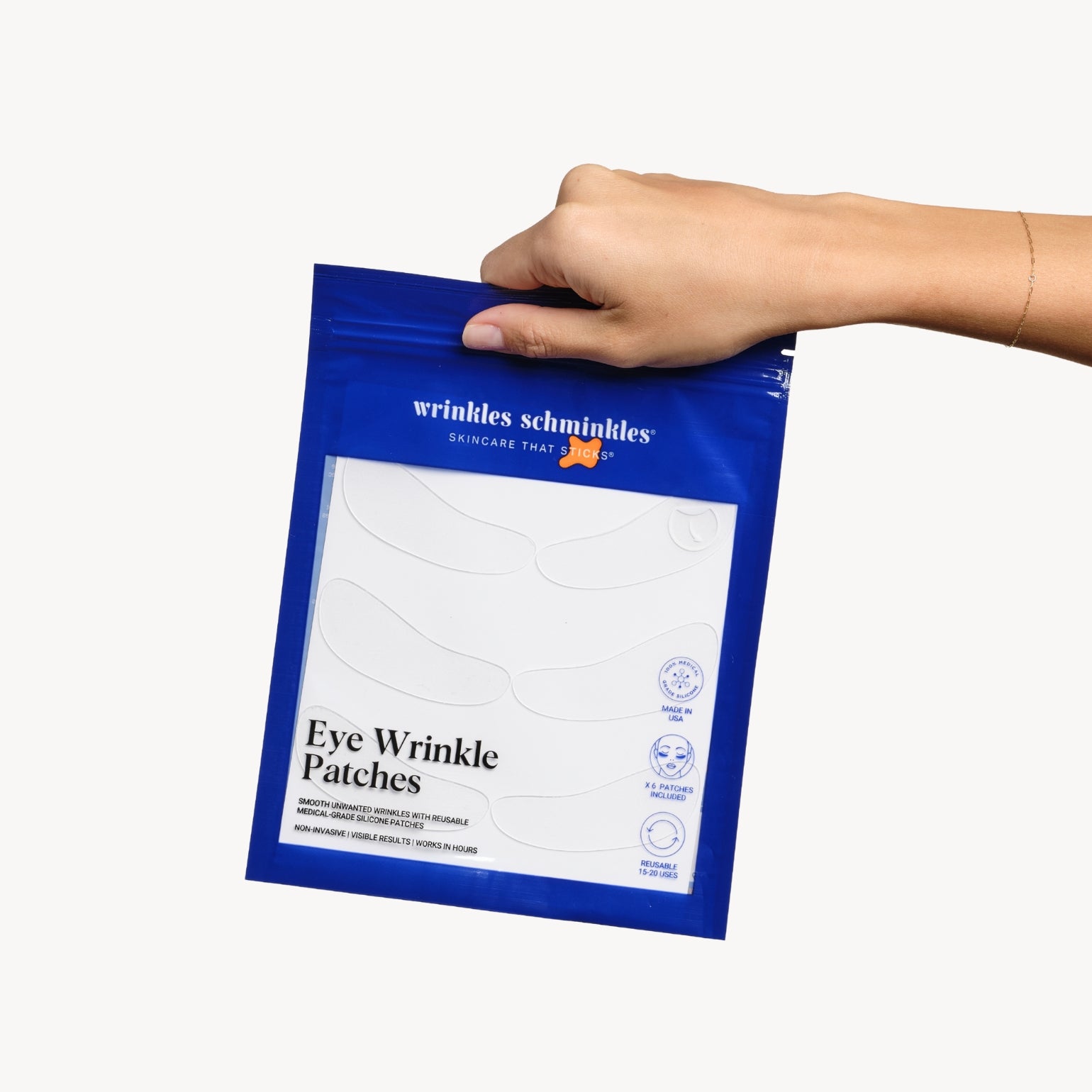 Main qui portent la boîte de 5 paires de Patchs Anti-Rides Des Yeux de Wrinkles Schminkles. Plus besoin d'injections !