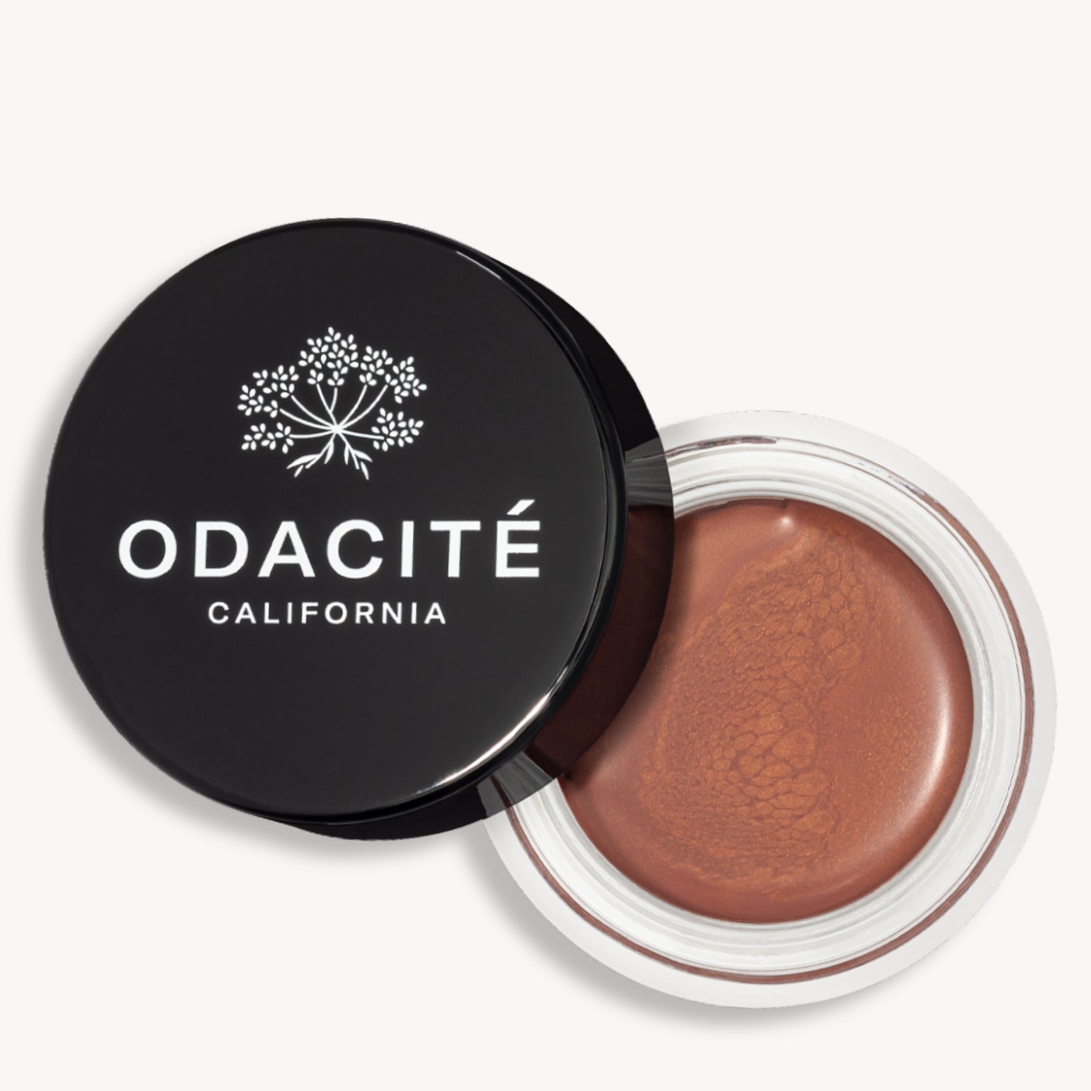 Pot ouvert de la teinte bronze jolie du Baume teinté SPF50 Odacité avec le capuchon