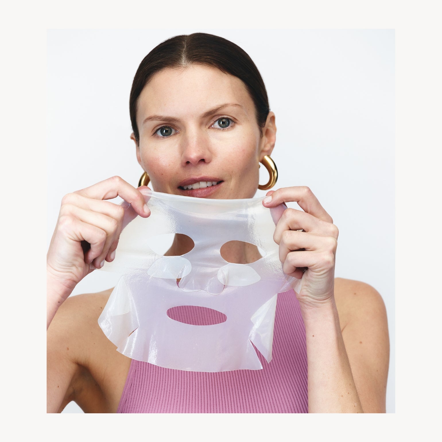 Modèle tenant un Masque en Tissu Repulpant Pour Le Visage de Wrinkles Schminkles. Collagène, Peptides, Acide Hyaluronique, Vitamine C.