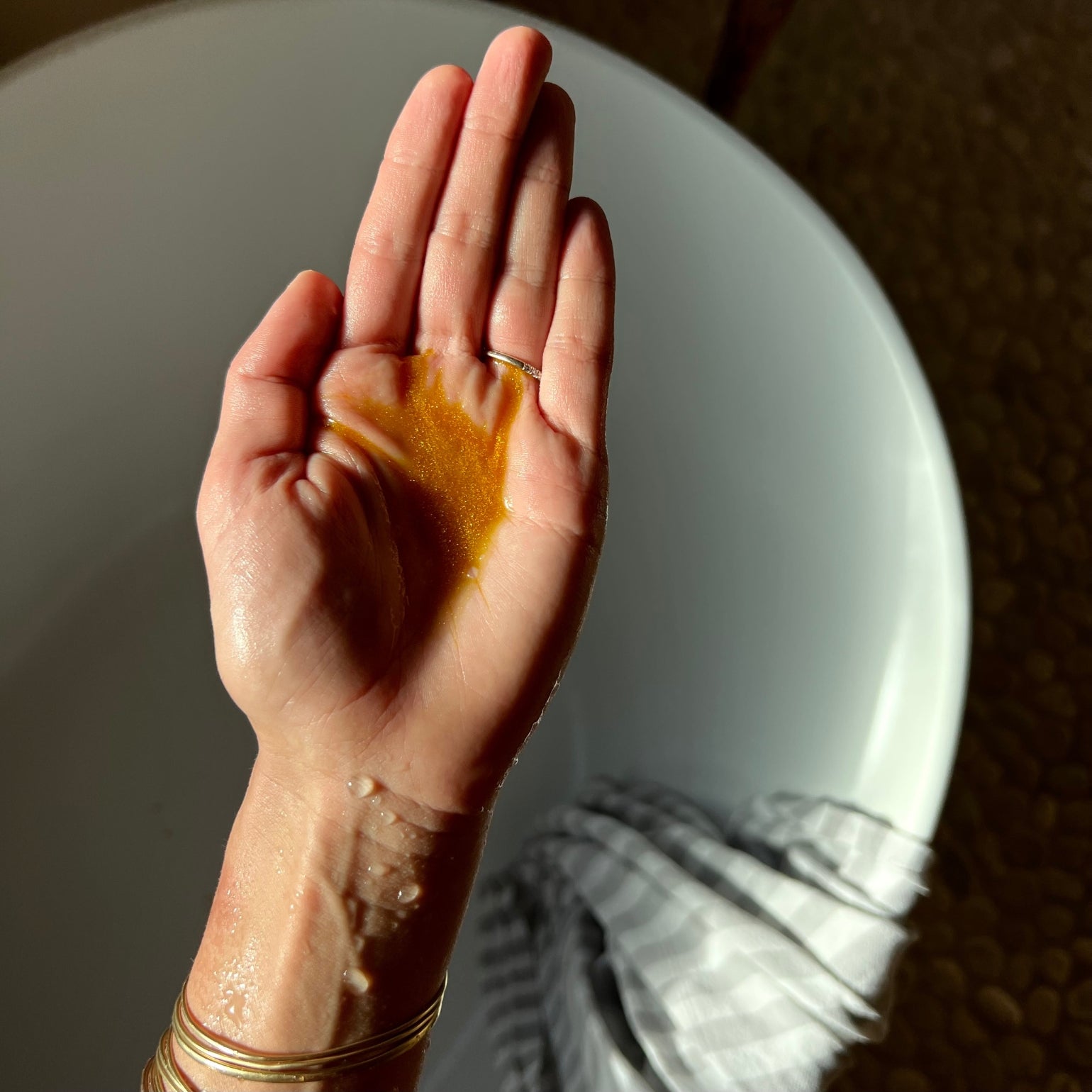 Main tenant The Good Stuff de May Lindstrom. Huile dorée et nourrissante.